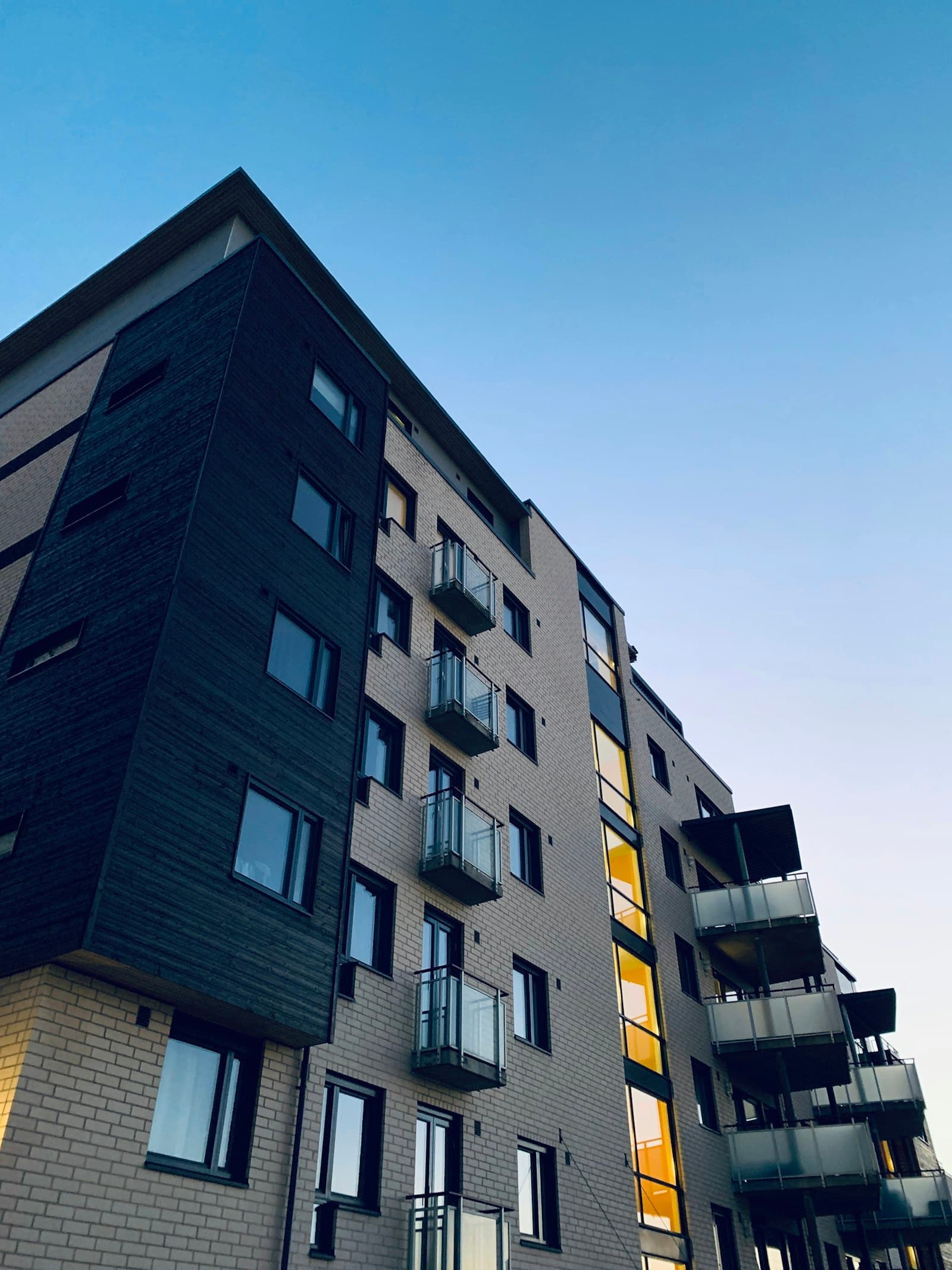 Modern apartment block with a lit stairwell at dusk